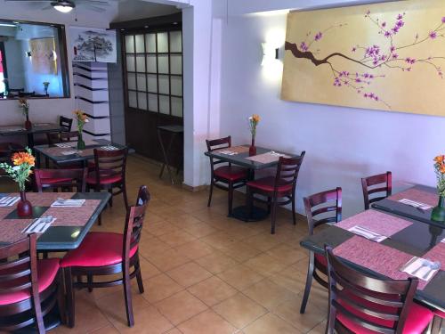 una sala da pranzo con tavoli e sedie e un dipinto sul muro di Ken Tehuacan a Tehuacán