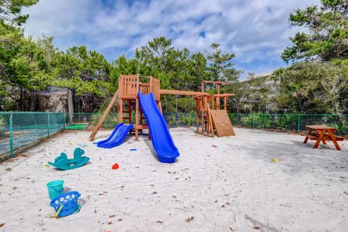 a playground with a slide and play equipment in the sand at High Pointe Resort in Panama City Beach