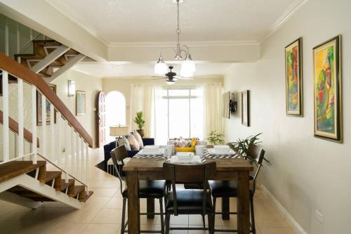 un comedor con mesa y sillas y una escalera en Choose To Be Happy at Surbiton Square - Two Bedroom Townhouse, en Kingston