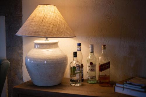 a lamp sitting on a table with bottles of wine at Casa Zeni in Cortona