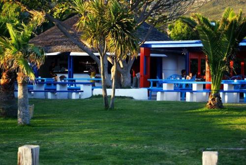 a resort with blue tables and palm trees in the grass at Bungalows Tangana in Tarifa