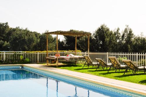 a pool with chairs and a table and a gazebo at Lisbon Country Villa in Oeiras