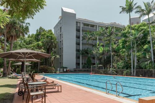 a swimming pool with a hotel in the background at Charlesworth Bay Beach Resort in Coffs Harbour