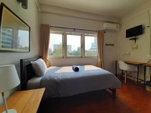 a bedroom with a bed and a chair and a window at Pingplalee Female House in Bangkok