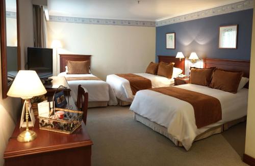 Giường trong phòng chung tại Hotel Emperador