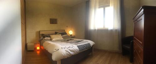 um pequeno quarto com uma cama e uma janela em La Découverte, Jacuzzi, Sauna, et Terrasse avec vue sur lac à la campagne entre Toulouse et Auch em Catonvielle