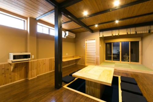 京都市にある染 SEN 五条一貫町 Gojo-Ikkannmachiのテーブルと電子レンジ付きの広い客室です。