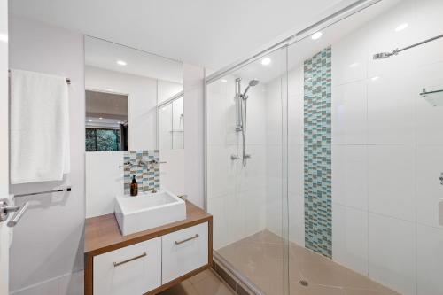 a white bathroom with a sink and a shower at Hunchy Hideaway in Montville