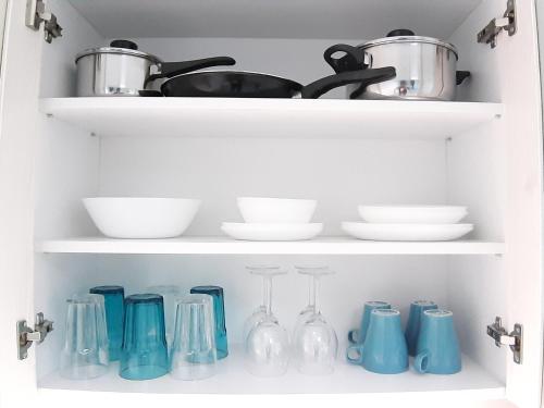 a kitchen shelf with dishes and utensils at Sarajevska Studio & Apartment in Belgrade