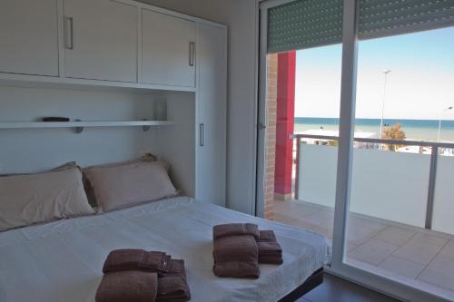 a bedroom with a bed and a view of the ocean at Residence La Nave in Senigallia