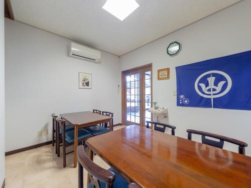 a dining room with a large wooden table and chairs at Tabist Business Hotel Fujiya in Emukae
