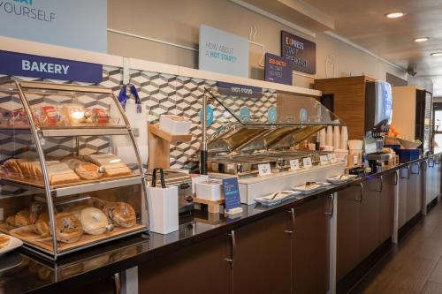 a bakery counter with a lot of bread and pastries at Holiday Inn Express Mountain View South Palo Alto by IHG in Mountain View