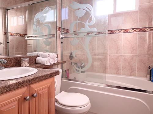 a bathroom with a toilet and a sink and a shower at Lisa’s lovely little house in Vancouver