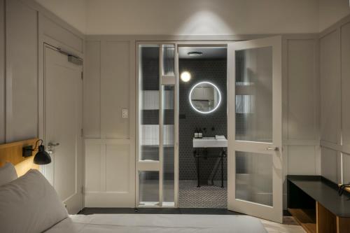 un baño con una puerta de cristal que conduce a un lavabo en Farmers Home Hotel, en Northam