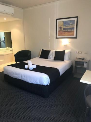 a hotel room with a bed with a teddy bear on it at Bay Motel Hotel in Adelaide