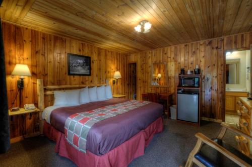 a bedroom with a bed in a room with wooden walls at Powder House Lodge in Keystone