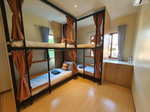 a room with three bunk beds in a house at Chada Mantra Hotel in Chiang Mai