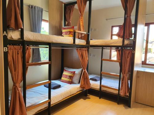 a room with three bunk beds in a hostel at Chada Mantra Hotel in Chiang Mai