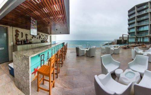 a restaurant with a bar with a view of the ocean at Departamento de playa - Condominio OCEAN REEF - SAN BARTOLO in San Bartolo