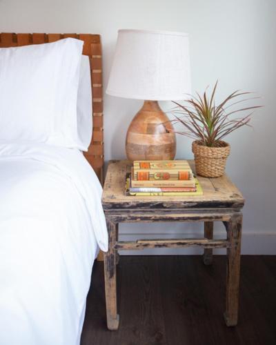 a bed with a table with a lamp and books at RubyJune Inn in White Salmon