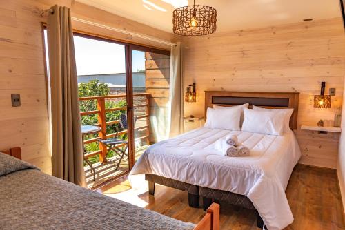 1 dormitorio con 1 cama grande y balcón en Hostel Moreno, en Pichilemu