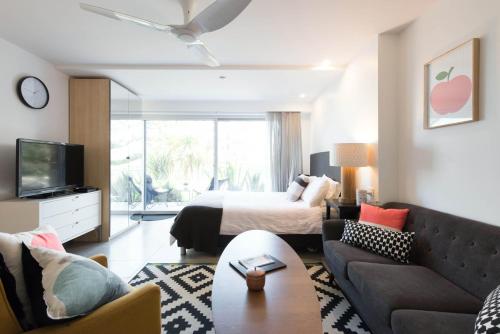una sala de estar con una cama y un sofá en Scandi Beach apartment, en Avalon
