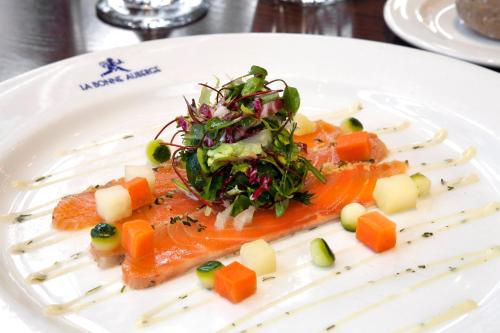 a white plate of food with salmon and vegetables at Holiday Inn - Glasgow - City Ctr Theatreland by IHG in Glasgow