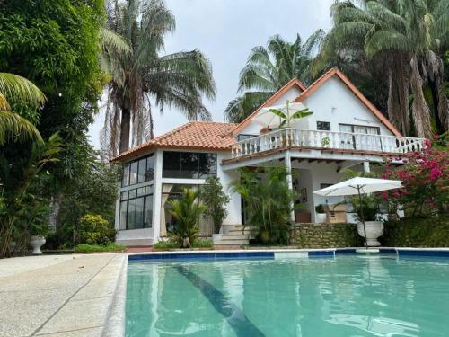 a house with a swimming pool in front of a house at Cabaña en Prado Tolima in Prado