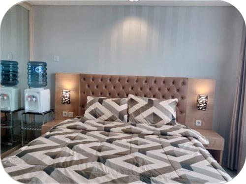 een slaapkamer met een groot bed met een groot hoofdeinde bij Channel Stay @ Bogor Icon Apartment in Bogor