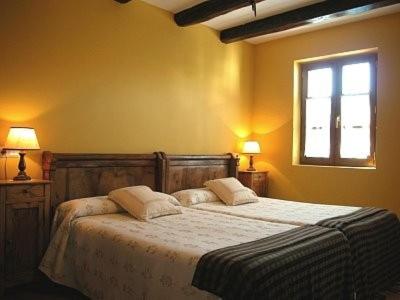 um quarto com uma cama com duas almofadas e uma janela em Apartamentos Rurales Kastonea em Errazu