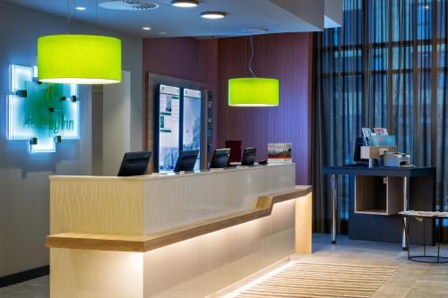 a lobby with a reception desk with neon green lights at Holiday Inn Frankfurt Airport, an IHG Hotel in Frankfurt