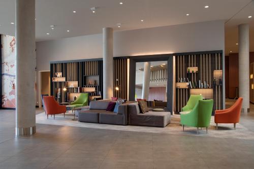 a lobby with a couch and chairs in a building at Holiday Inn Frankfurt Airport by IHG in Frankfurt/Main