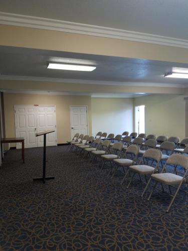 an empty room with chairs and a podium in it at Mid City Inn & Suites Pico Rivera in Pico Rivera