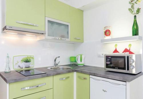 una cucina con armadi verdi e forno a microonde di Apartment Ivka - in center a Opuzen