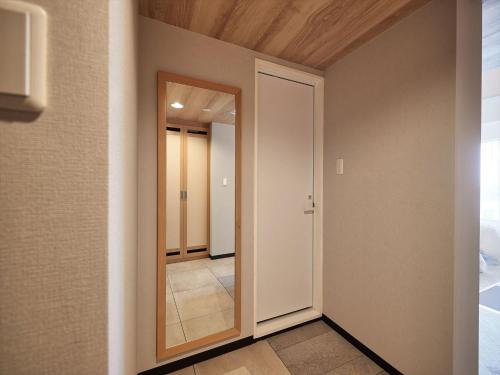 a hallway with a door and a mirror at Palace In Moon Beach in Onna