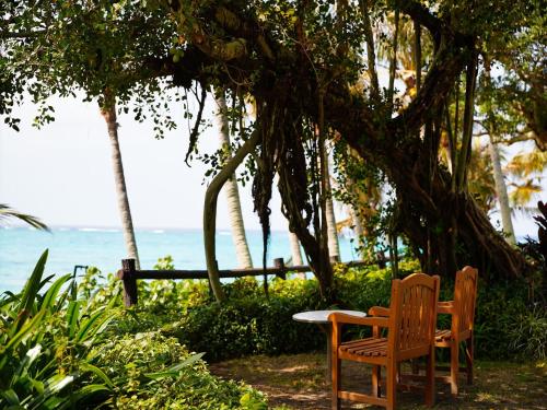 two chairs and a table in front of the ocean at Palace In Moon Beach in Onna