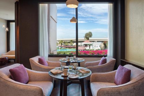 a restaurant with chairs and tables and a large window at Crowne Plaza Bahrain by IHG in Manama