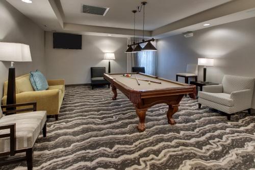 a living room with a pool table and two chairs at Staybridge Suites Missoula by IHG in Missoula
