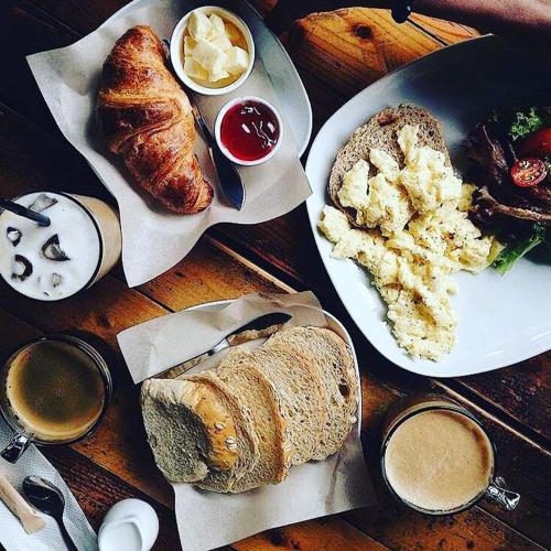 a table with two plates of bread and pastries at Kim Haus Loft in George Town
