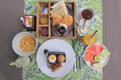 a table with plates of food and a cup of coffee at KajaNe Mua at Ubud Bali in Ubud