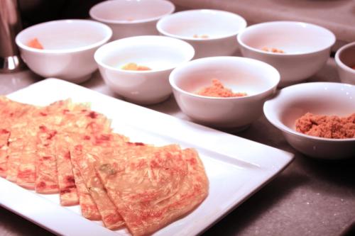 a white plate with some food on a table at Pullman Changshu Leeman in Changshu