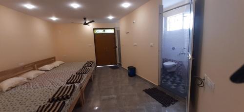 a room with two beds and a shower at Godwill Kimo Guest house Seraulim in Madgaon