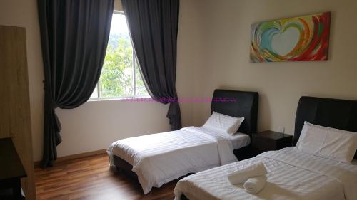 a hotel room with two beds and a window at Seri Jati Homestay in Papar