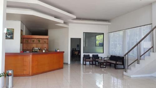 eine Küche und ein Wohnzimmer mit einem Tisch und Stühlen in der Unterkunft Tiara Inn in Ternate