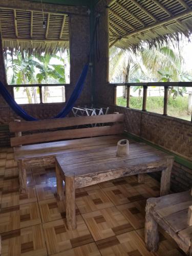 - un banc en bois dans une chambre avec fenêtres dans l'établissement Bale'ku, à Pangandaran