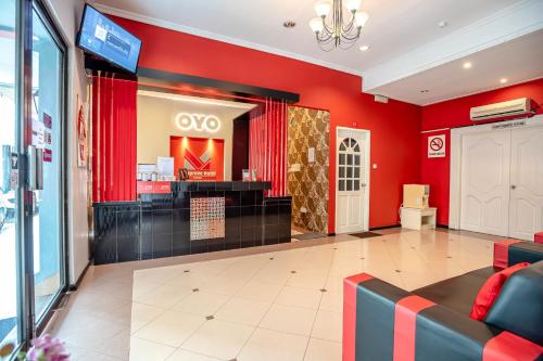 a store lobby with a red wall and avsoc store at OYO 89568 Mangrove Hotel in Tawau