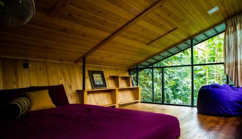 a bedroom with a bed and a large window at Arana Sri Lanka Eco Lodge and Yoga Center in Ella