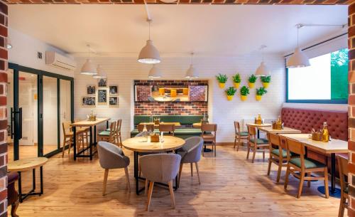 a restaurant with wooden tables and chairs and a brick wall at bloomrooms @ Janpath in New Delhi