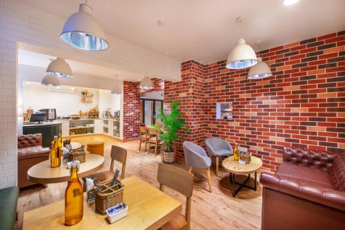 a living room with a brick wall and tables and chairs at bloomrooms @ Janpath in New Delhi