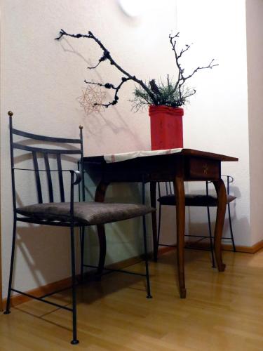 a table and a chair with a vase on it at Haus Matt in Laterns